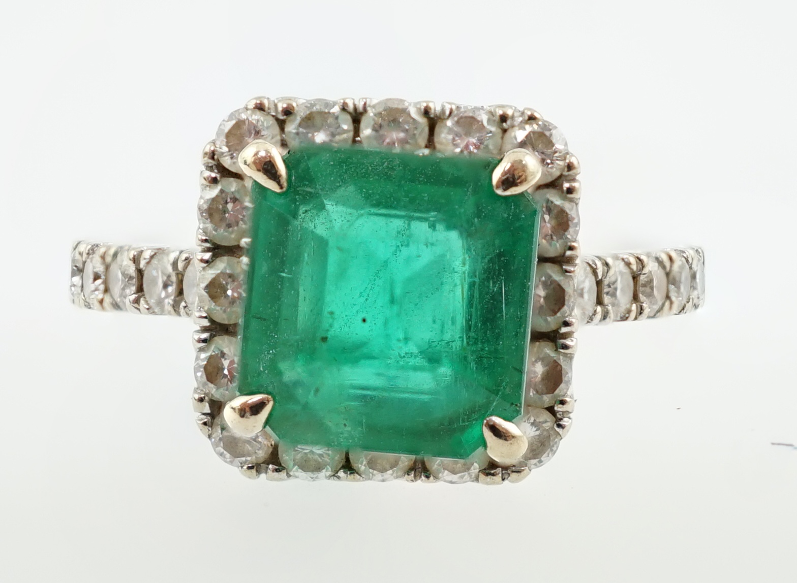 A modern 18k white gold, emerald and diamond set square cluster ring